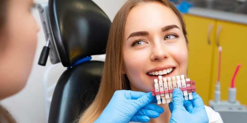 Dentist,Selects,A,Shade,Of,Teeth,Whitening,Using,Shade,Guide Cosmetic Dentistry taylorsville